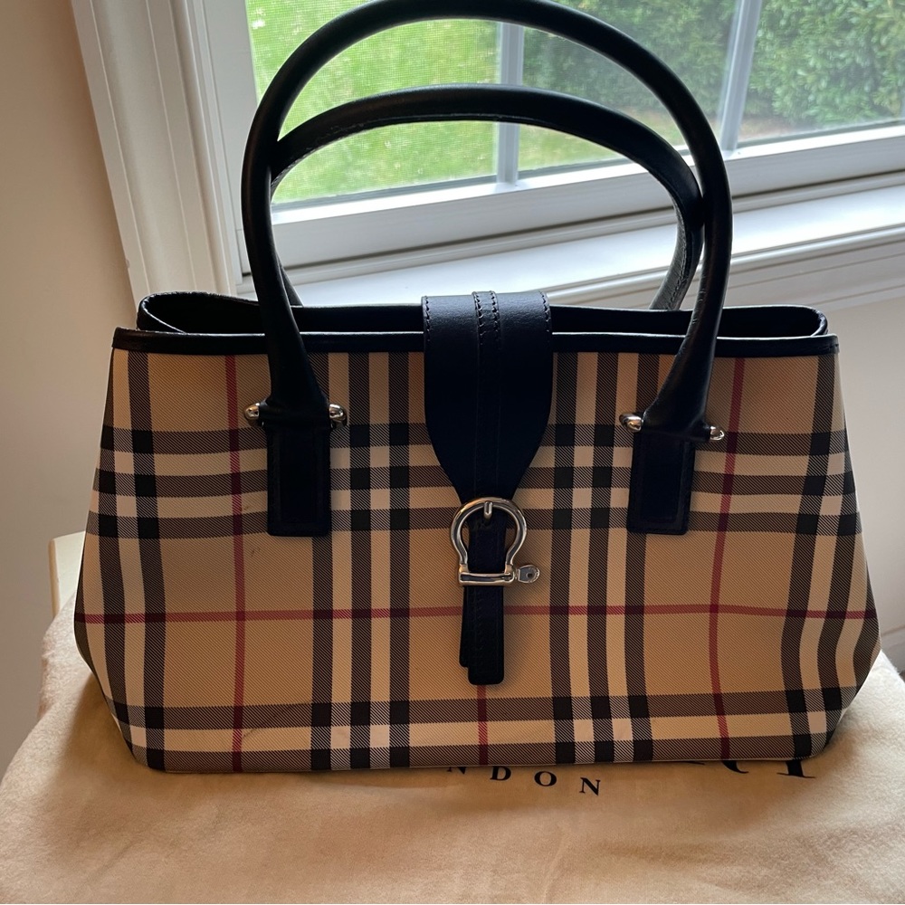 Burberry handbag. Inside zip, exterior snaps. Bit design handles and closure.
